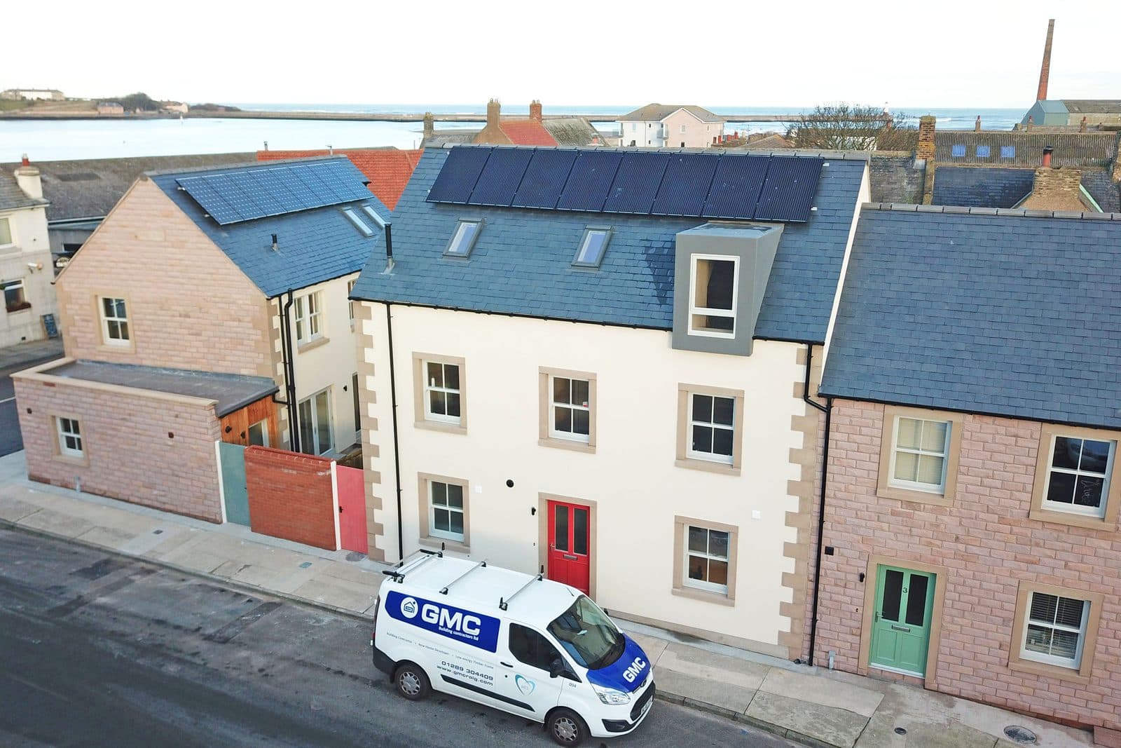 Solar panels on a terrace roof with a GMC van outside